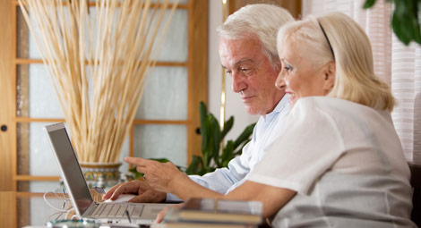 An older lady and man using a laptop